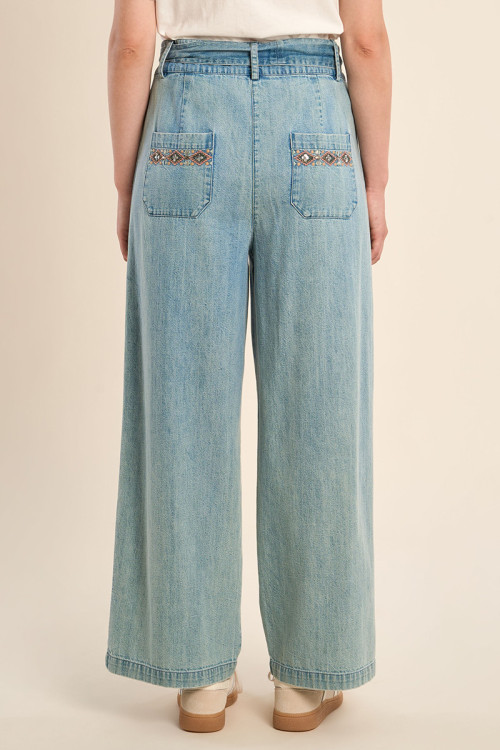 Pantalón de mujer largo, vaquero, con lazada y abalorios.