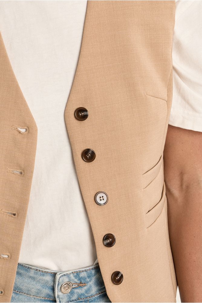 Chaleco de mujer entallado, detalle doble boble bolsillo.