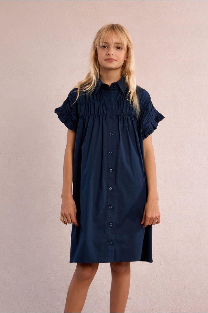 Vestido de niña corto, camisero, con pliegues.