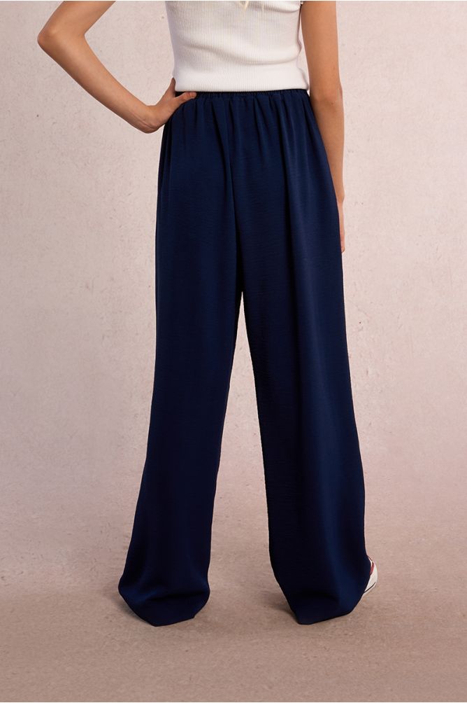 Pantalón de niña largo, con pliegues y lazada.