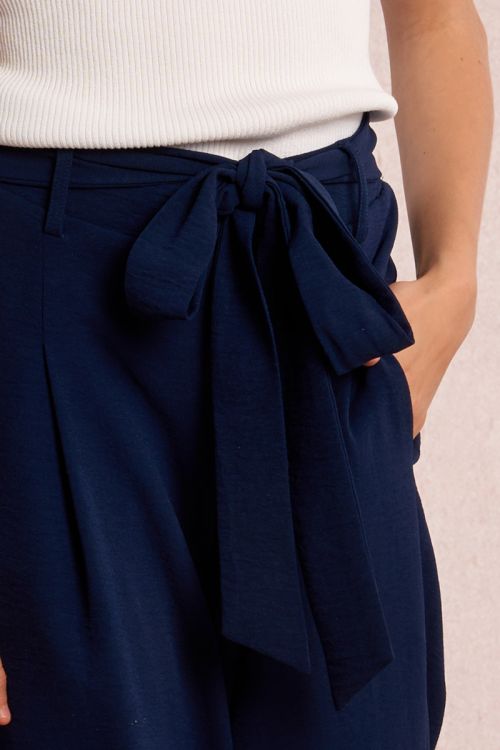 Pantalón de niña largo, con pliegues y lazada.