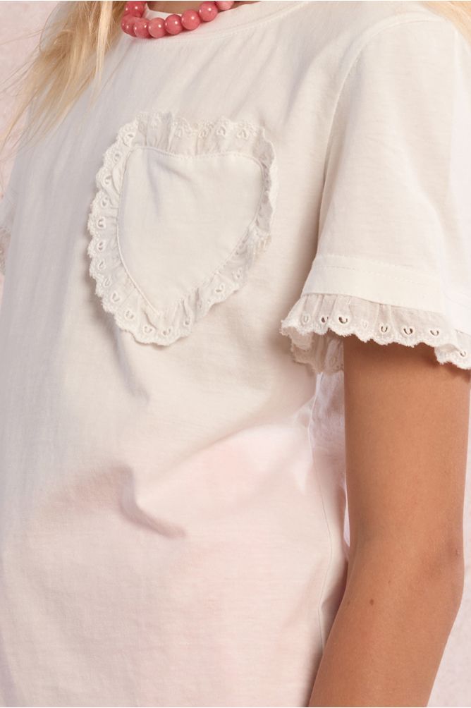 Camiseta de niña de manga corta, detalle corazón y volantes.