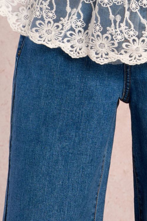 Pantalón de niña largo, vaquero, perneras anchas.